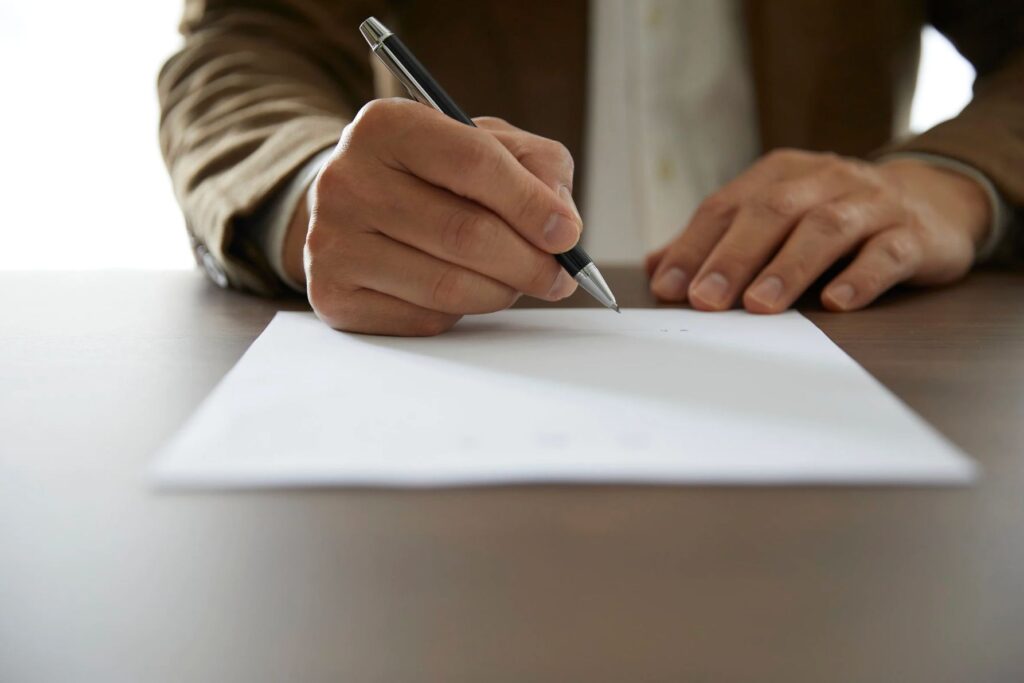 Persona firmando un contrato de compraventa