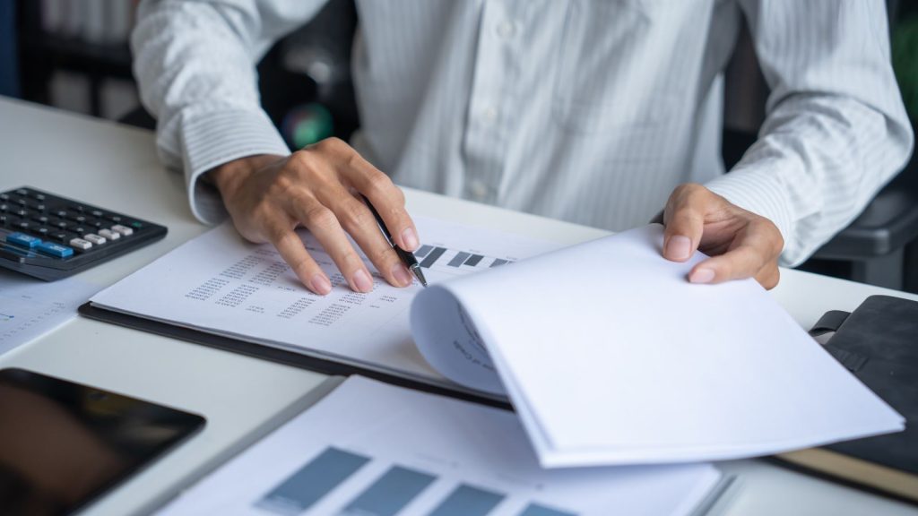 Contador calculando el monto de una multa del SII con calculadora y planillas financieras