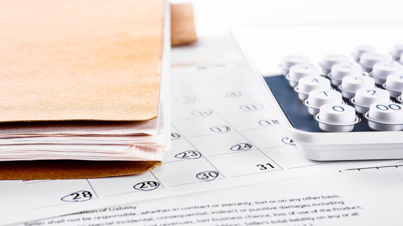 Calendario con los días de vencimiento del Formulario 29 junto a una calculadora y una carpeta de documentos tributarios