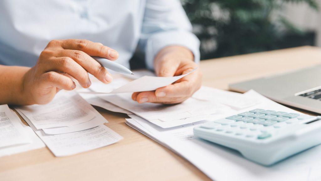 Contador revisando y clasificando boletas y comprobantes de gastos antes de la declaración de renta