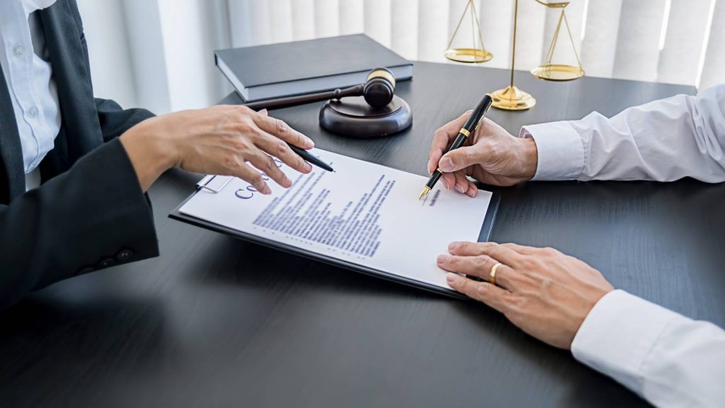 Abogado y cliente firmando un contrato de asesoría legal sobre fideicomiso y herencia en Chile